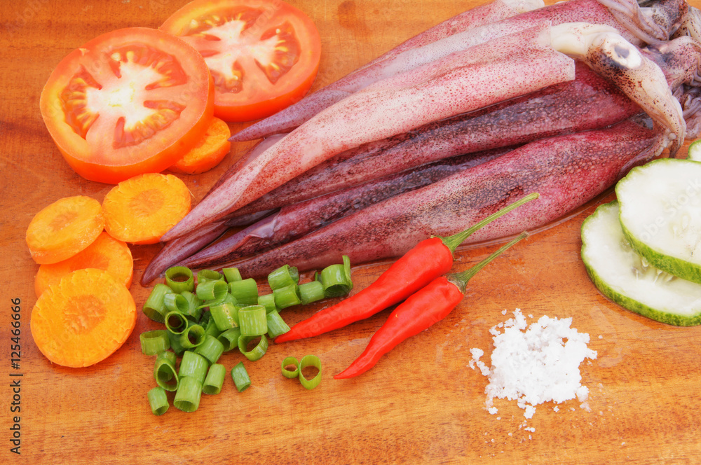 Cooking squids, squids and vegetables on wooden board Cooking squids, squids and vegetables on wooden board