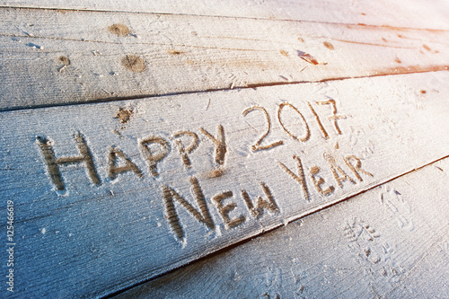 Happy New Year 2017 written on a wooden background with frosts