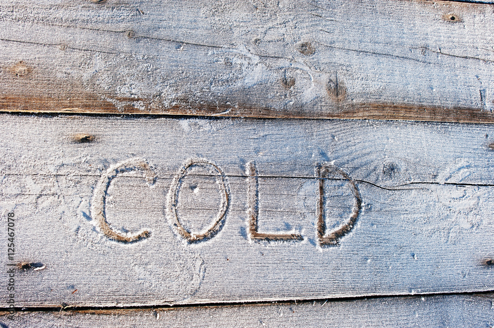 Cold written on a wooden background with frosts