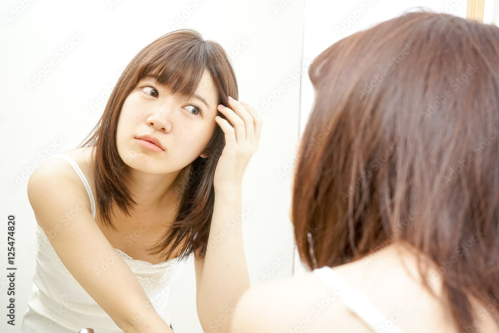 Young woman treating her hair on the white background Young woman treating her hair on the white background