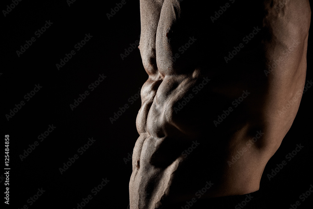 torso of attractive male body builder on black background. torso of attractive male body builder on black background.