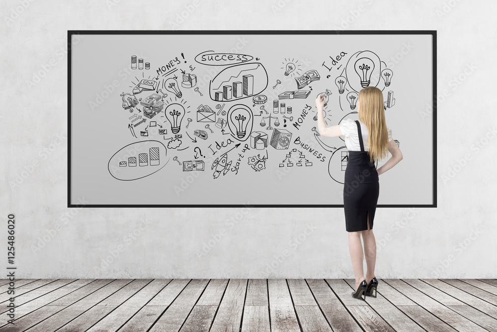 Blond woman is drawing business sketches on whiteboard Blond woman is drawing business sketches on whiteboard