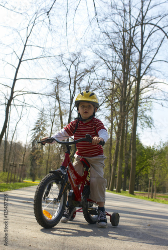 Young boy riding his first bicycle with training wheels  © Petr Bonek