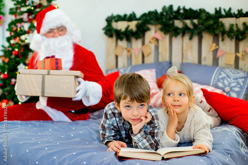 Santa Claus quietly came to the children who are reading Santa Claus quietly came to the children who are reading