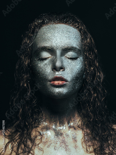 Girl in glitter Girl in glitter on her face with wet curly hair on black background Close-up © Picture Store