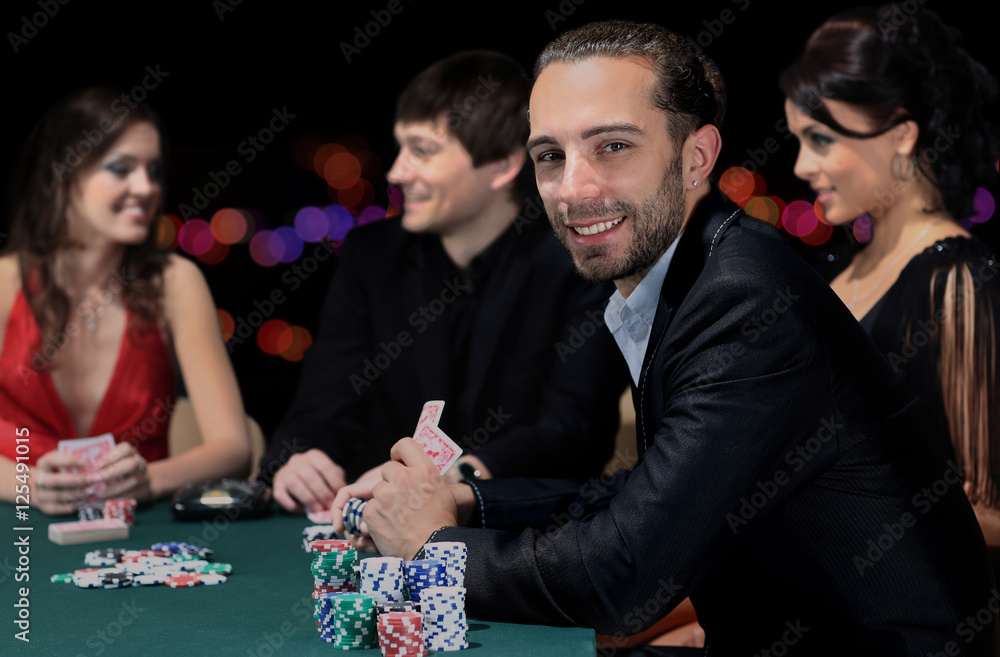 Poker players sitting around a table at a casino Poker players sitting around a table at a casino
