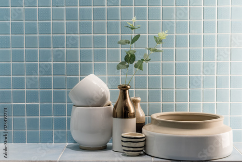 ceramic vase and bowl decoration in a bathroom with blue mosaic tile