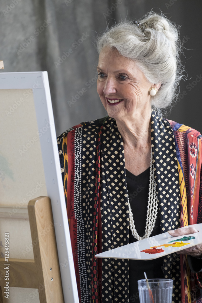 Fototapeta premium Portrait of a senior aged woman painting a picture