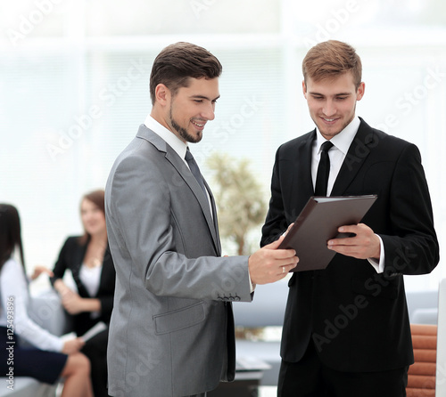 Two successful business partners discussing documents and ideas  © ASDF