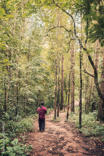 hill tribe man walking along a forest trail in northern Thailand
