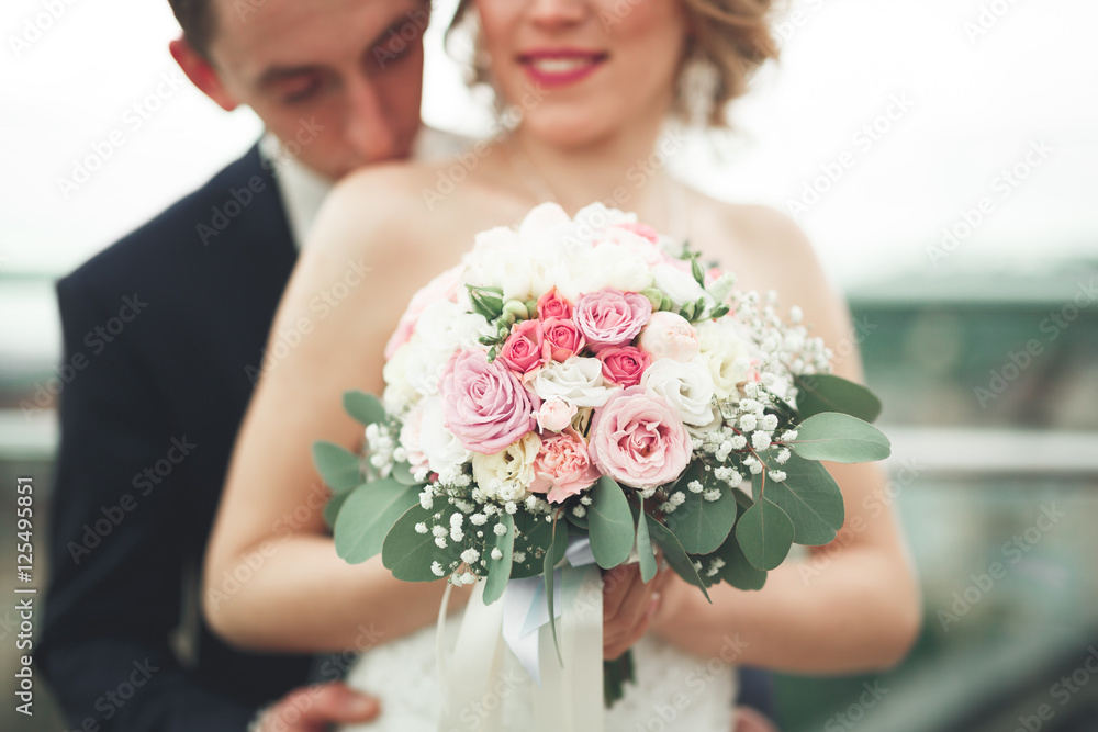 Just married wedding couple posing and bride holding in hands bouquet Just married wedding couple posing and bride holding in hands bouquet