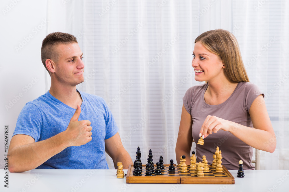Happy couple enjoys playing chess.
Happy couple enjoys playing chess.