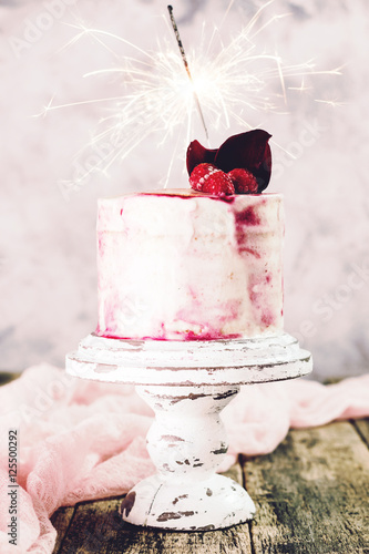 Birthday cake with sparkler on wooden vintage table