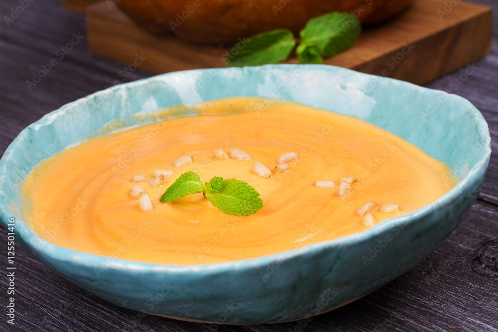 Bowl of pumpkin soup and whole pumpkin. Butternut squash cream soup Bowl of pumpkin soup and whole pumpkin. Butternut squash cream soup