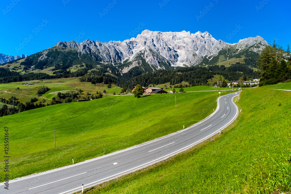 Naklejka premium Beautiful alpine summer landscape. Mountains and sun, blue sky,