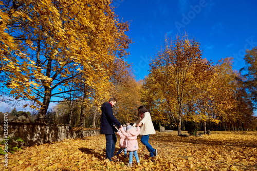 Happy family playing in the park beautiful autumn. Mother, fathe photo