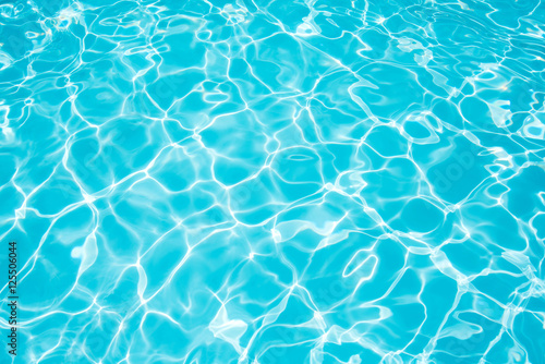 Ripple blue water in swimming pool witn sun reflection