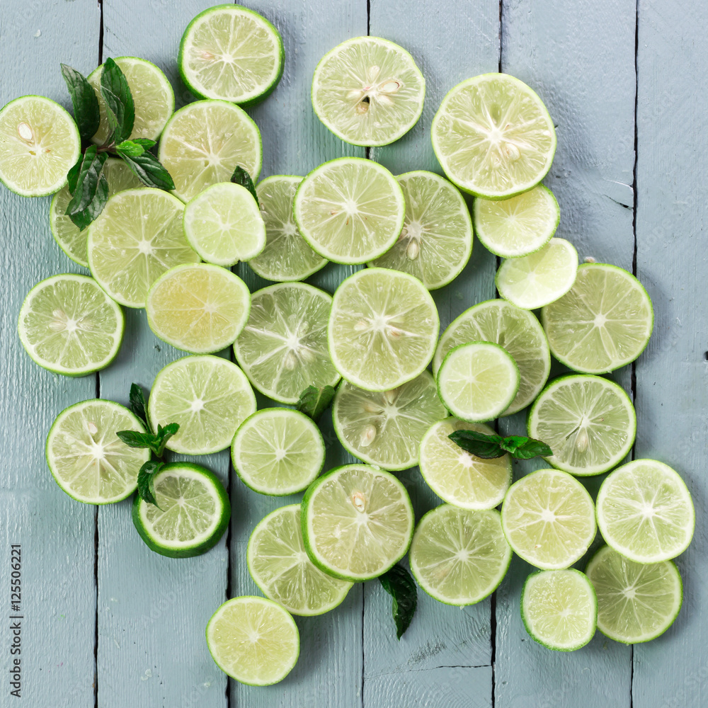 Lime background. Fresh limes with slices and mint leaves around. Lime background. Fresh limes with slices and mint leaves around.
