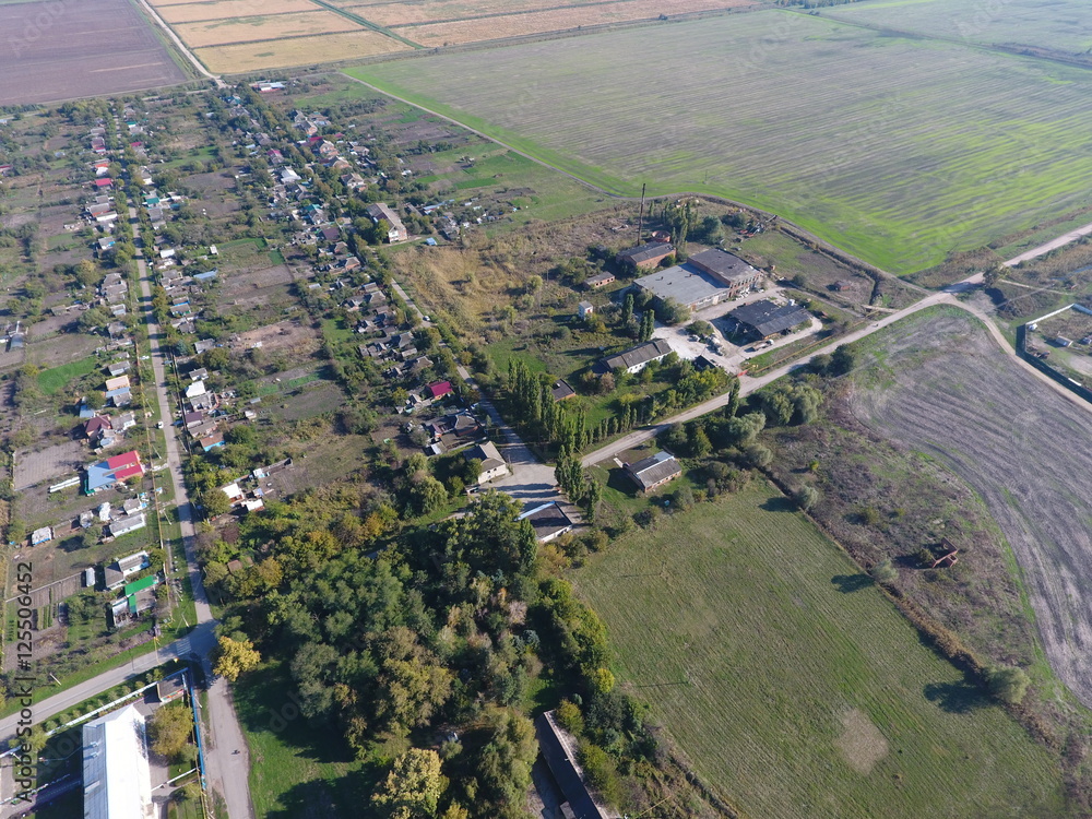 Top view of the village. One can see the roofs of the houses and gardens. Road in the village. Village bird's-eye view