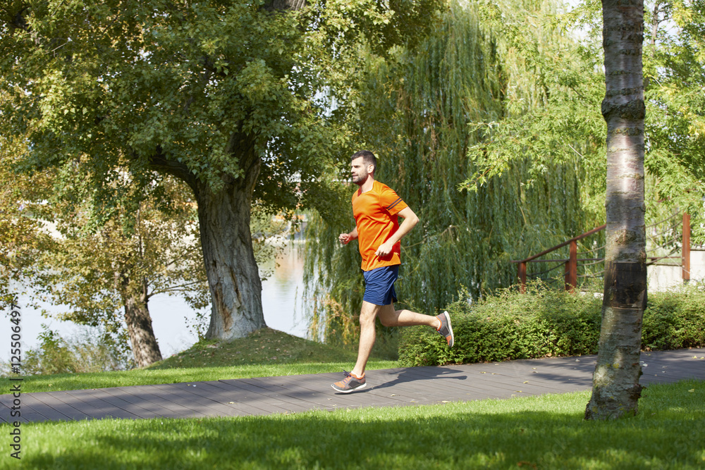 Morning running. Full length shot of young man running in the park in the morning. Morning running. Full length shot of young man running in the park in the morning.