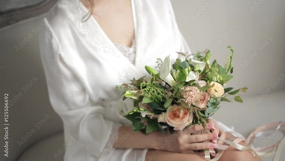 Bride holds beautiful small bouquet with flamingo ribbons. Bride holds beautiful small bouquet with flamingo ribbons.
