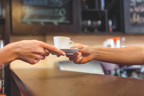waiter giving mug of latte to a client