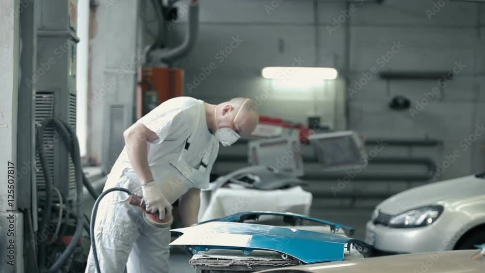 Man changes the nozzle on a grinding machine. Man changes the nozzle on a grinding machine.