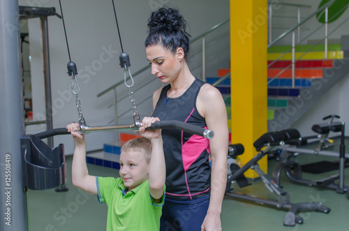 Mother helping son in the gym photo