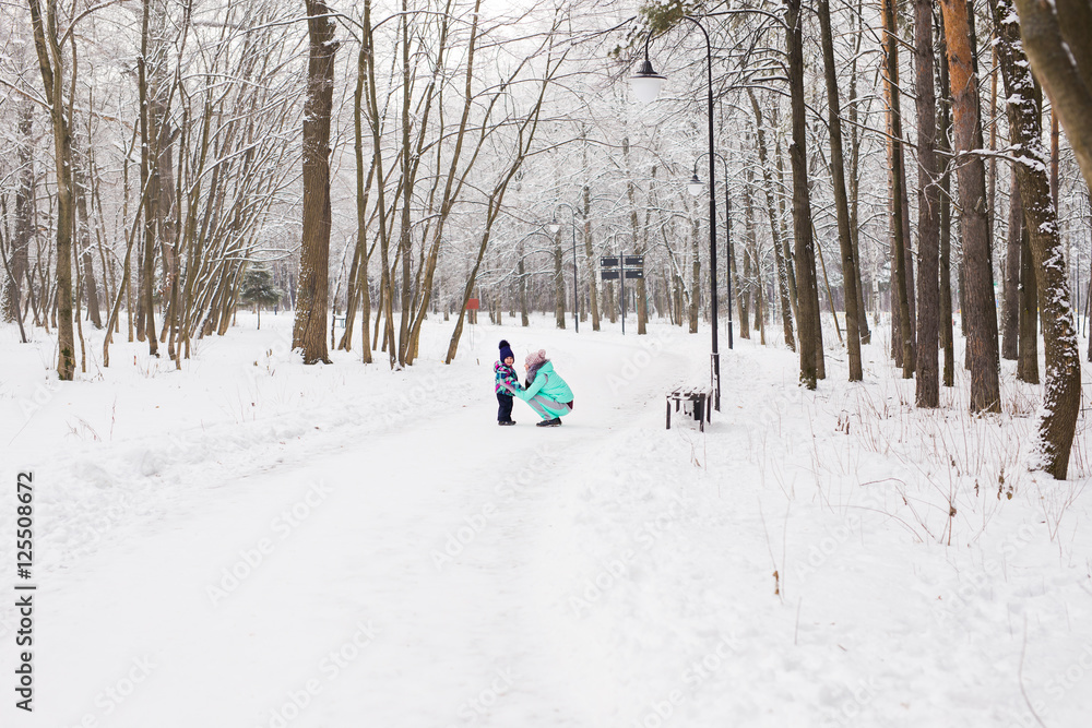 happy mother and baby in winter park. family outdoors. cheerful mommy with her child happy mother and baby in winter park. family outdoors. cheerful mommy with her child