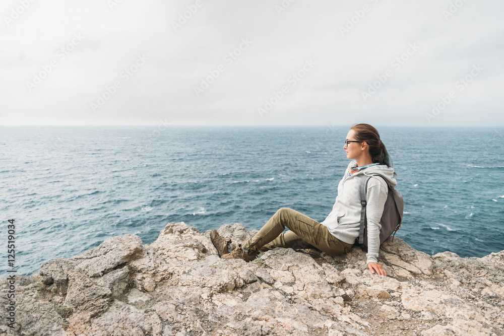 Tourist resting on rocky coast