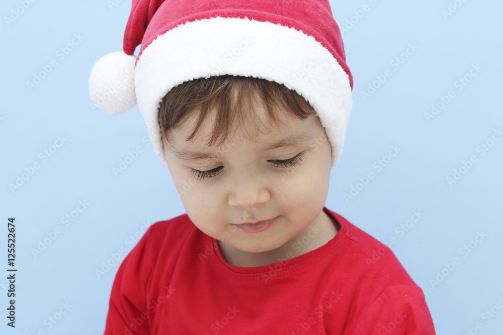 little kid dressed as Santa Claus looking down little kid dressed as Santa Claus looking down