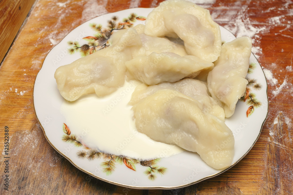 Delicious dumplings with cherries, sour cream in plate. Delicious dumplings with cherries, sour cream in plate.