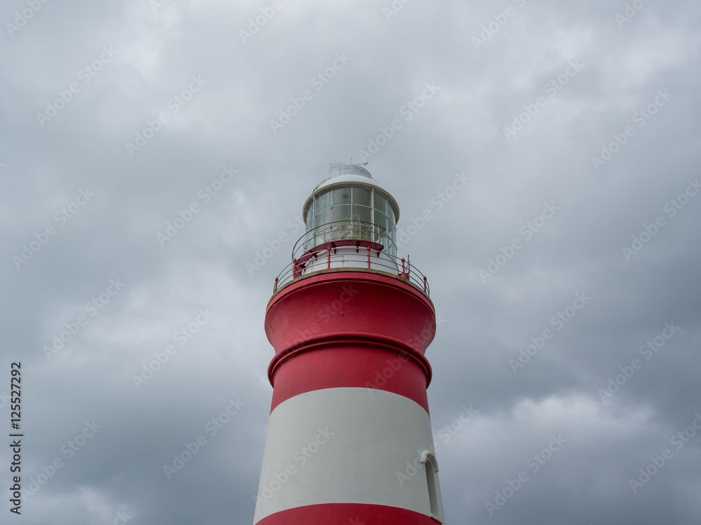 The historic lighthouse at Cape Alguhas in South Africa on a dramatic cloudy day