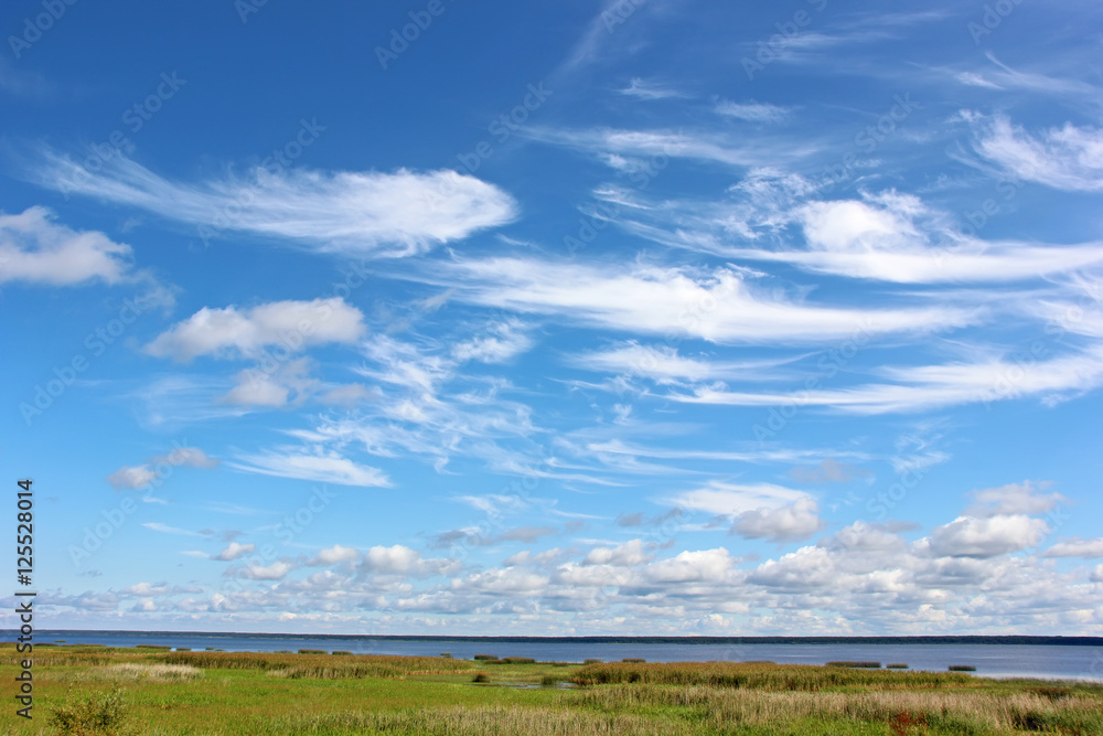 Blue sky with Cirrus clouds over the sea.