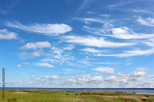 Blue sky with Cirrus clouds over the sea.