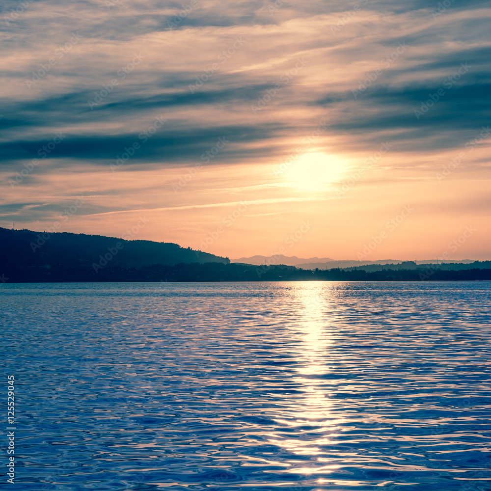 Fantastic evening at the lake. Sun sets behind the horizon. Fantastic evening at the lake. Sun sets behind the horizon.
