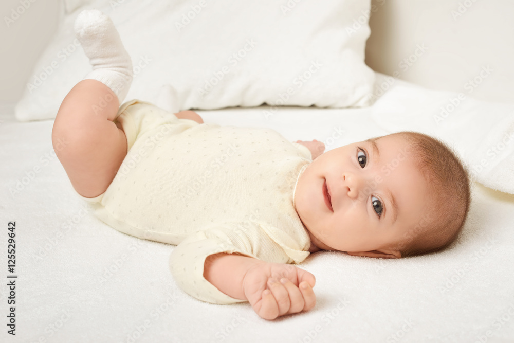 baby portrait lie on white towel in bed, yellow toned baby portrait lie on white towel in bed, yellow toned