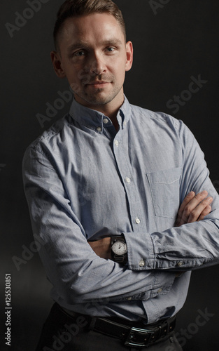 Portrait of young businessman on dark background