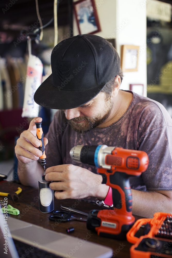 Man using screwdriver in the workshop Man using screwdriver in the workshop