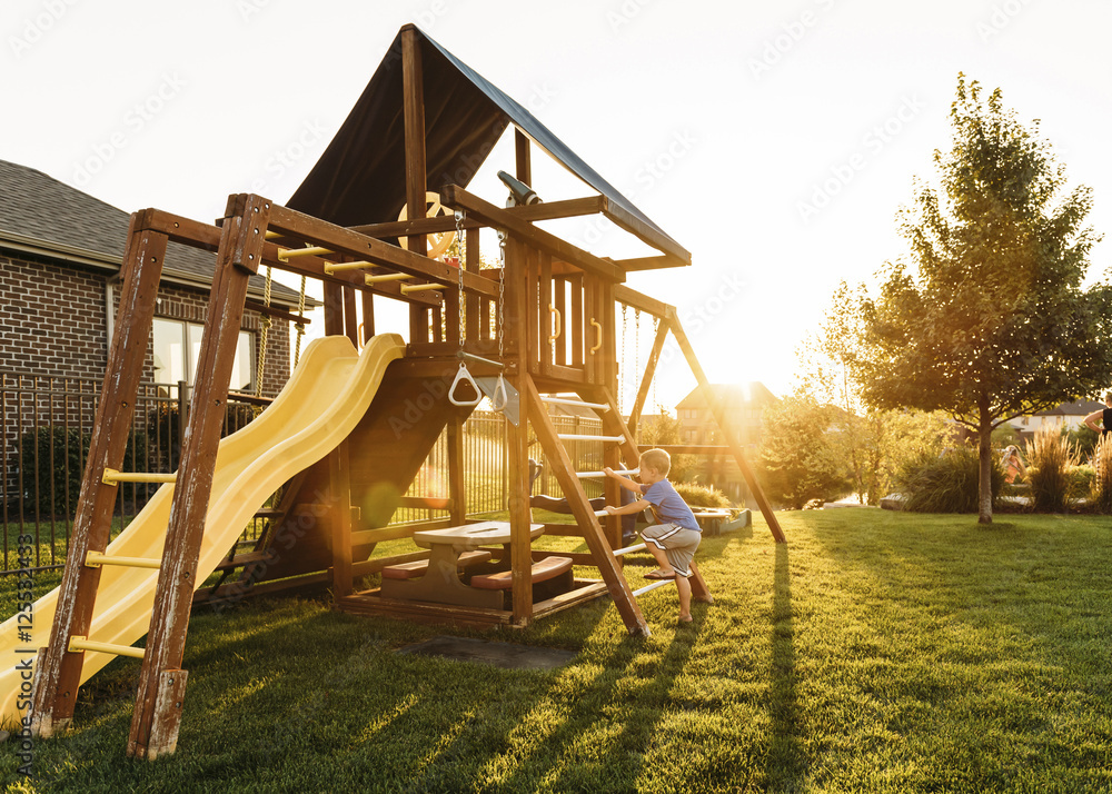 Boy playing in backyard during sunset Boy playing in backyard during sunset
