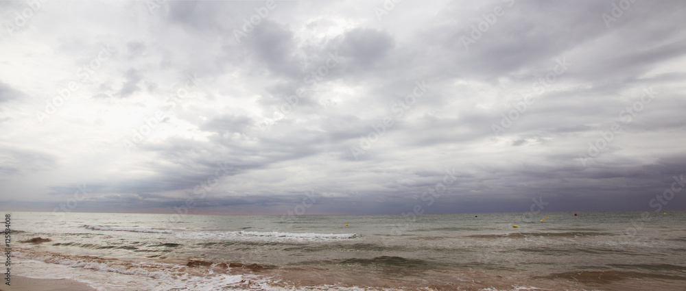 beach with dark clouds panorama