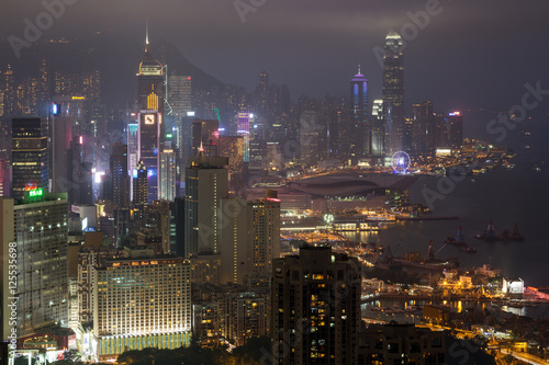 Lit skyscrapers and other buildings on Hong Kong Island in Hong Kong  China  viewed from the Braemar Hill on a foggy and cloudy evening. 