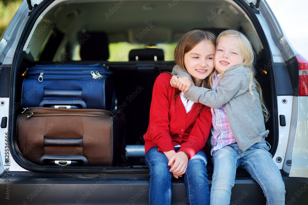 Two adorable little sitting in a car before going on vacations with their parents Two adorable little sitting in a car before going on vacations with their parents