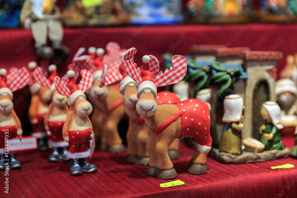 Colorful close up details of christmas fair market. Wooden deer figures decorations for sales
