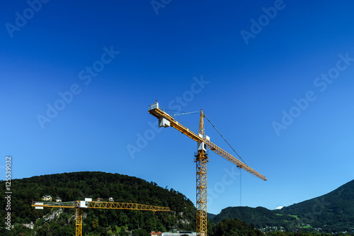Big crane over the city on blue sky background