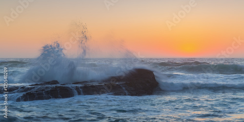 Waves breaking on a background of sea sunset.