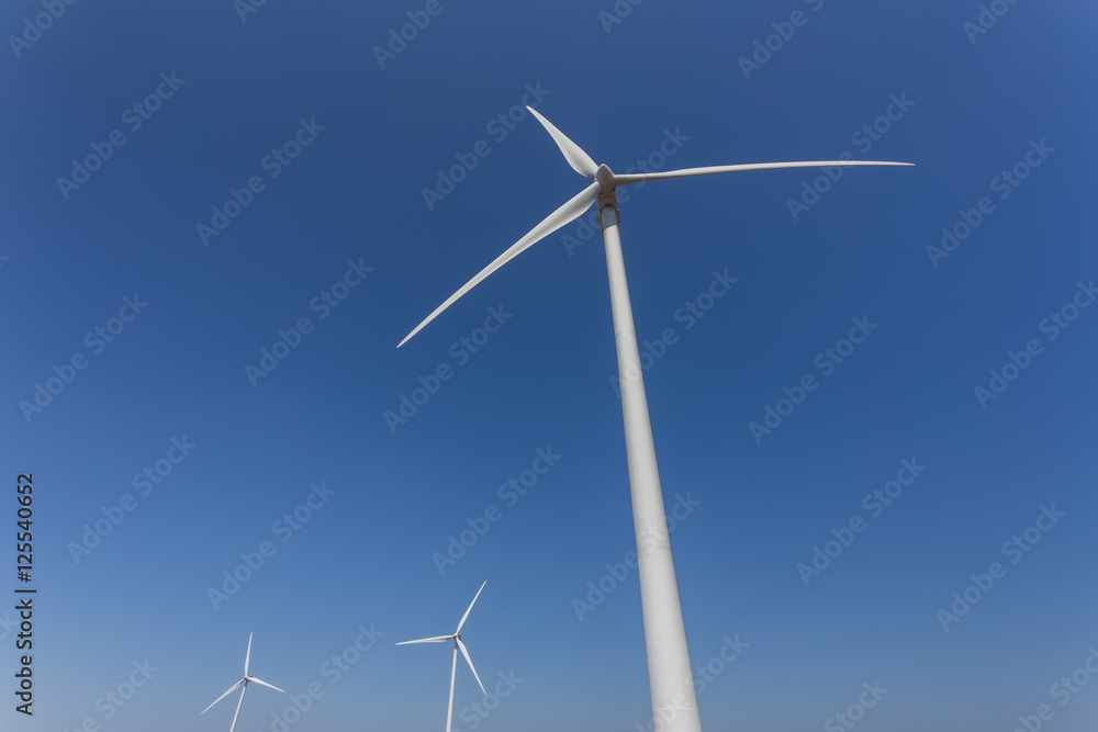 Wind generators from below, against a blue sky. Wind generators from below, against a blue sky.