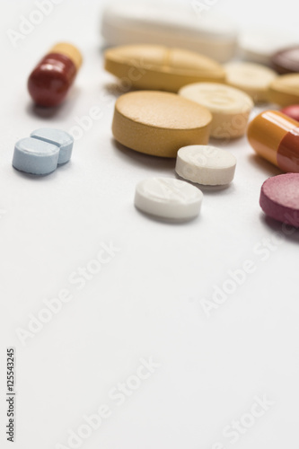 Multiple pills depicting medical treatment or pahrmaceutical ind