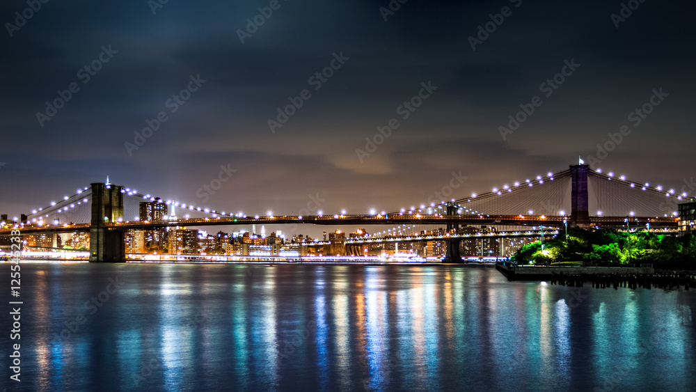 Brooklyn Bridge and Manhattan skyline by night viewed from Pier2 park in New Yok City