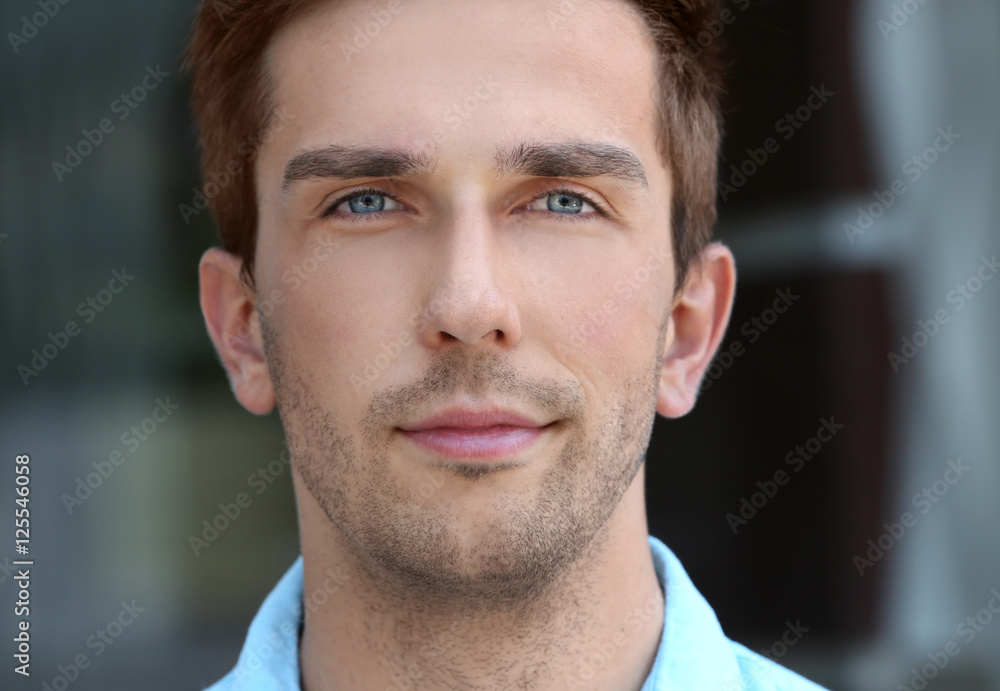 Fototapeta premium Young handsome businessman on blurred background